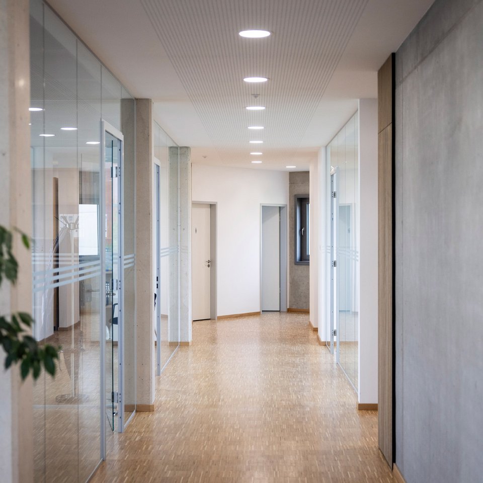 Innenraum mit Holzfußboden, Wandverkleidung und Lichtdurchflutung – stilvoller Innenausbau.