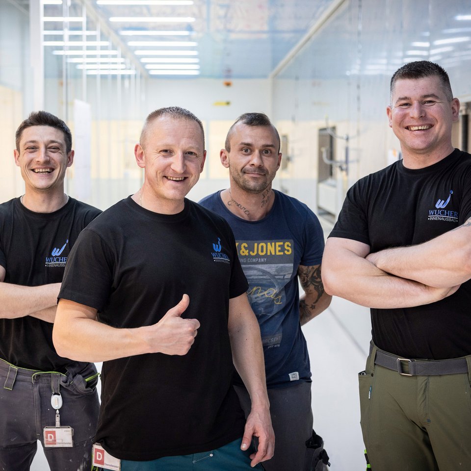 Drei Mitarbeitende der Wucher GmbH in schwarzer Arbeitskleidung – freundliches Teamfoto.